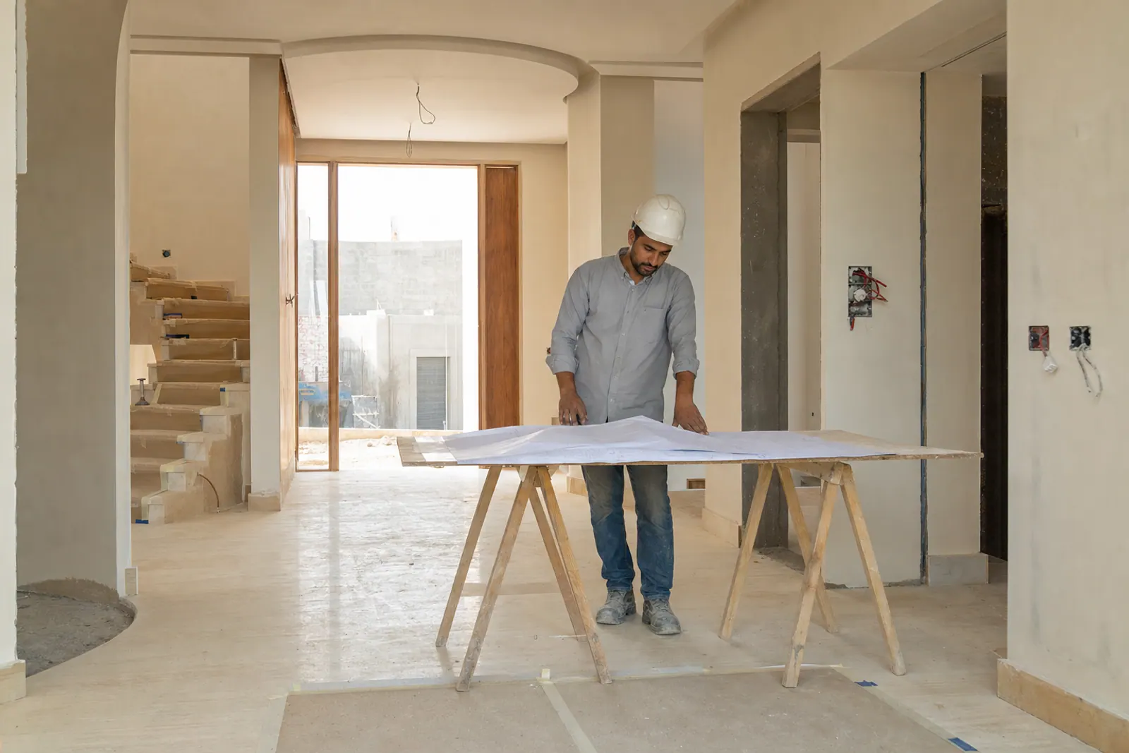Foreman reviewing work inside a villa under finishing.