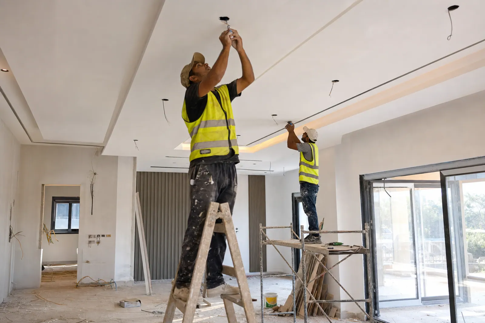 Interior crew installing ceiling and lighting details.
